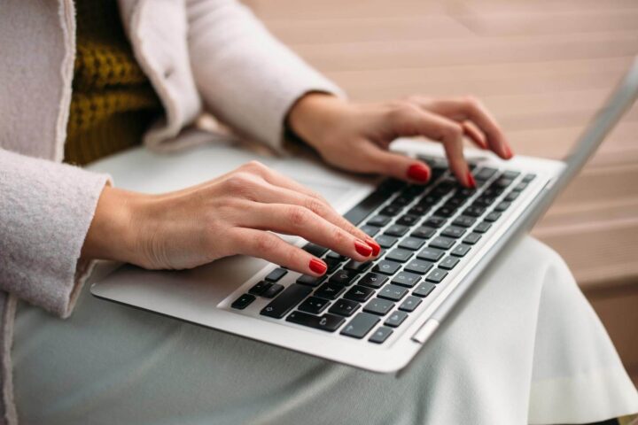 Woman typing on a laptop keyboard.